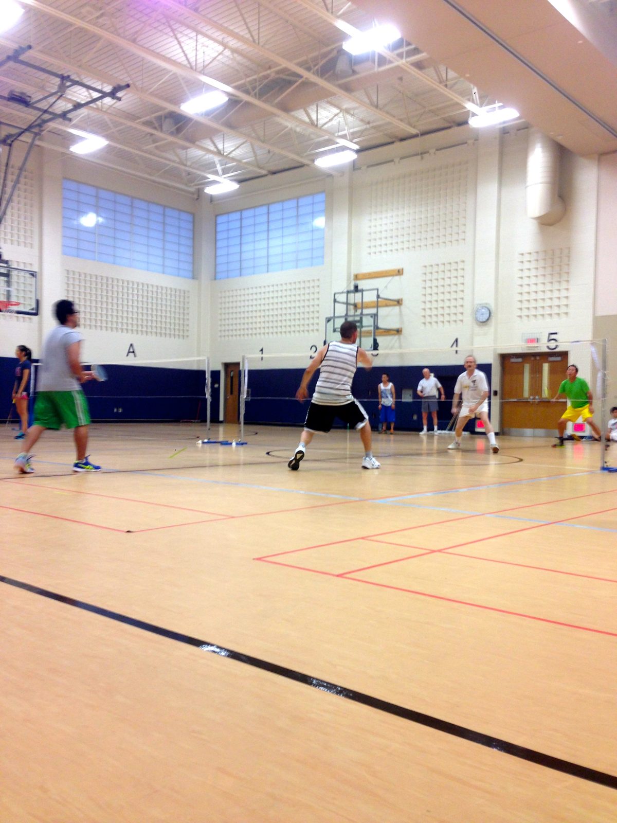Several doubles games in progress across the gym