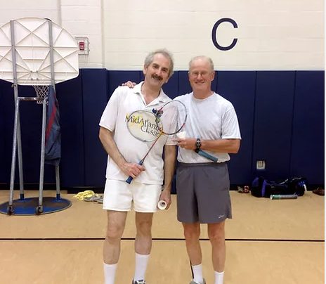 Two members with a trophy racket after a tournament